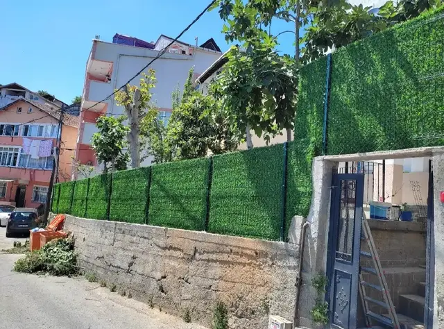 Yokuşlu sokakta taş duvar üzeri çimçit